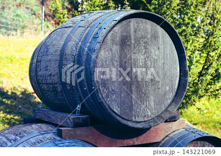A group of old wooden barrels stacked on a wooden pallet. 143221069