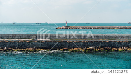 Lighthouse by the Sea with Stone Breakwater 143221278