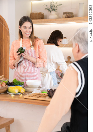 Caucasian family with adult daughter preparing food together in kitchen 143222362