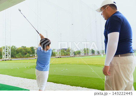 Golf instructor teaching basic stance and setup to young Asian boy Golf instructor teaching basic stance and setup to young Asian boy 143222445
