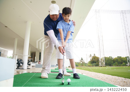 Professional golf coach guiding young student ball address position 143222450