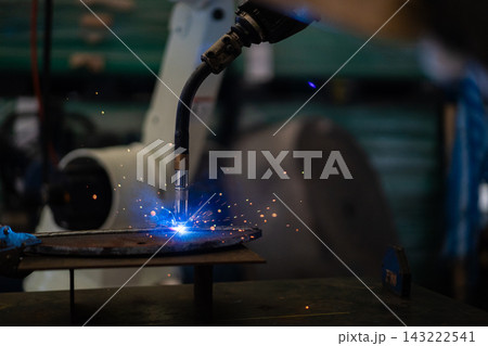 Close up of robotic welding torch welding metal with bright sparks 143222541