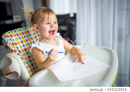 Cute little girl painting with felt-tip pen at home. Creative games for kids. Stay at home entertainment 143223910