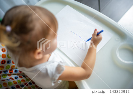 Cute little girl painting with felt-tip pen at home. Creative games for kids. Stay at home entertainment 143223912