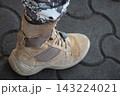 Legs of a soldier in camouflage and army boots on the concrete paver. 143224021