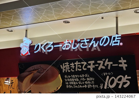 Illuminated Rikuro's Ojisan no Mise storefront sign featuring freshly baked Japanese cheesecake advertisement in Osaka, Japan. 143224067