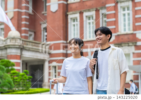 旅行するアジア人観光客のカップル。観光、観光客、インバウンド、来日、日本、東京、笑顔、駅、夫婦、国旗 143225020