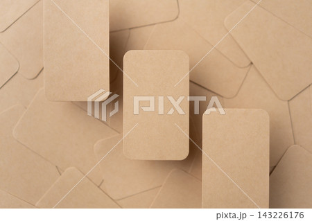 Top view of blank kraft paper rounded corner business cards scatter background with copy space 143226176
