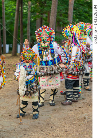Kukeri group, performers in colorful ritual mask, traditional Bulgarian folk costumes, cowbells, walking stick. Group of masked performer, cultural festival, Kotel, Bulgaria Kukeri group, performers in colorful ritual mask, traditional Bulgarian folk costumes, cowbells, walking stick. Group of masked performer, cultural festival, Kotel, Bulgaria 143226594
