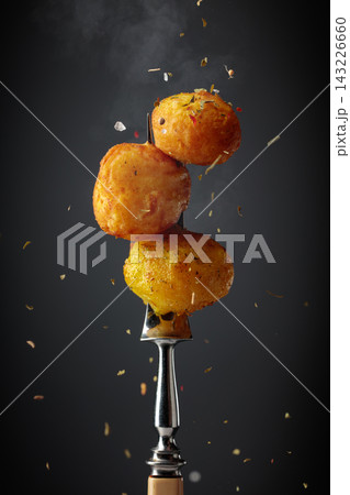 Roasted potatoes sprinkled with a mixture of herbs and spices. 143226660