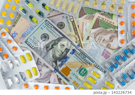 Money and pills: a symbol of the rising cost of medicines in the world and in Ukraine. 2018 Money and pills: a symbol of the rising cost of medicines in the world and in Ukraine. 2018 143226734