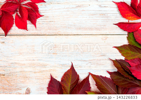 Red Leaves Are Arranged in a Pattern on a Wooden Surface During Autumn Season 143226833