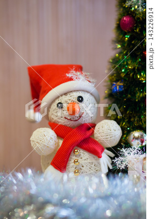 A cheerful snowman under the Christmas tree 143226914