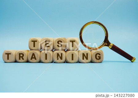 Test Training alphabet letters wooden cube and magnifying glass on blue background Test Training alphabet letters wooden cube and magnifying glass on blue background 143227080
