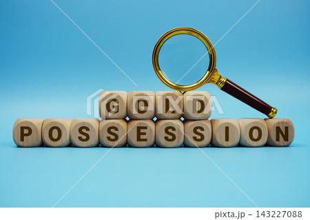Gold Possession alphabet letters wooden cube and magnifying glass on blue background Gold Possession alphabet letters wooden cube and magnifying glass on blue background 143227088