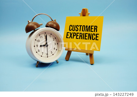 Customer Experience text written on paper card and alarm clock on blue background Customer Experience text written on paper card and alarm clock on blue background 143227249
