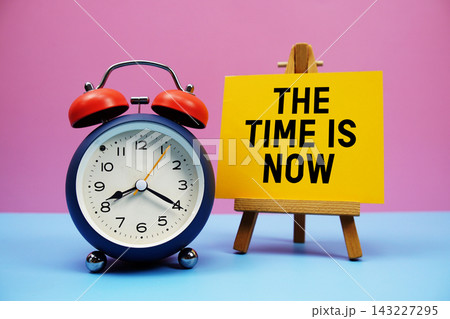 The Time Is Now text with alarm clock on pink and blue background 143227295
