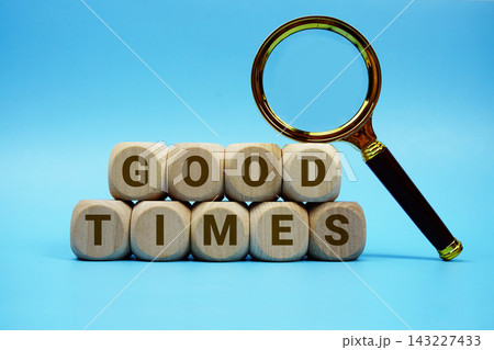 Good Times alphabet letters wooden cube and magnifying glass on blue background Good Times alphabet letters wooden cube and magnifying glass on blue background 143227433
