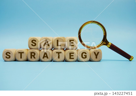 Sale Strategy alphabet letters wooden cube and magnifying glass on blue background 143227451