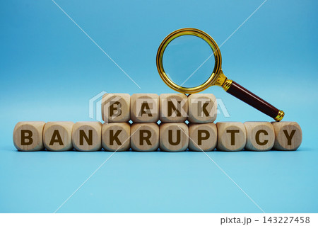 Bank Bankruptcy alphabet letters wooden cube and magnifying glass on blue background 143227458