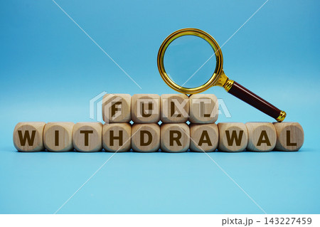 Full Withdrawal alphabet letters wooden cube and magnifying glass on blue background 143227459