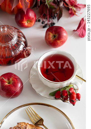 Autumnal Fruit Tea Served with Fresh Apples and Pastry on White Table 143227695