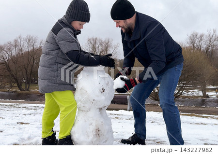 Dynamic family lifestyle photo showing happy father playing winter outdoor games with his cute son. 143227982
