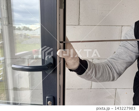 Manual window frame adjustment. Manual adjustment of a new balcony door in a newly built apartment Manual window frame adjustment. Manual adjustment of a new balcony door in a newly built apartment 143227983