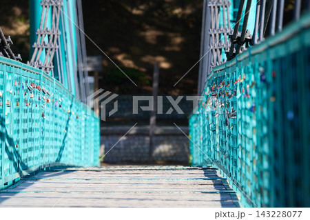 Turquoise Suspension Bridge Covered With Love Locks 143228077