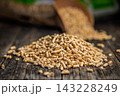 Scoop of Wood Pellets Spilling From Bag for Heating Fuel and Sustainable Biomass Energy 143228249