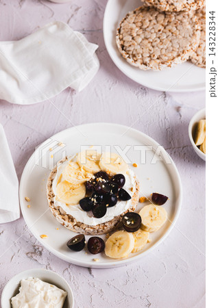 Fruit, berries, and ricotta on grain bread on a plate on the table vertical view Fruit, berries, and ricotta on grain bread on a plate on the table vertical view 143228344