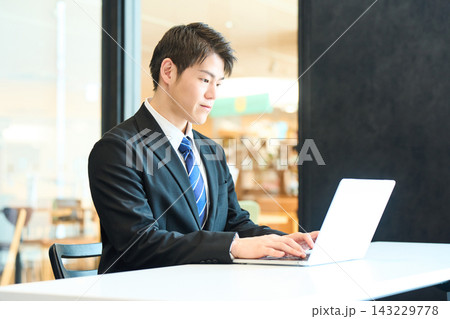 パソコンで仕事をするスーツ姿の日本人男性 パソコンで仕事をするスーツ姿の日本人男性 143229778
