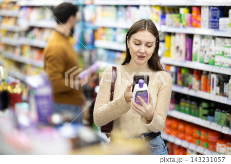 Young woman scanning QR code on care products 143231057