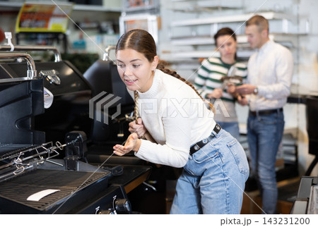 In store, girl inspects mobile grill, buys barbecue device In store, girl inspects mobile grill, buys barbecue device 143231200
