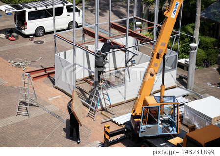 空調服を着た建設作業員・とび職が仮設事務所を組立てる建設現場 143231899