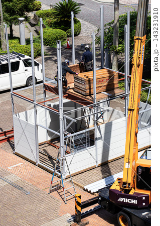 空調服を着た建設作業員・とび職が仮設事務所を組立てる建設現場 空調服を着た建設作業員・とび職が仮設事務所を組立てる建設現場 143231910