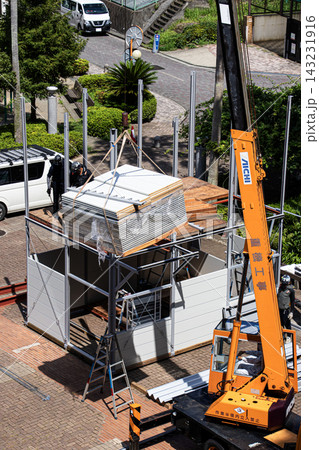空調服を着た建設作業員・とび職が仮設事務所を組立てる建設現場 143231916