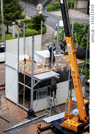 空調服を着た建設作業員・とび職が仮設事務所を組立てる建設現場 空調服を着た建設作業員・とび職が仮設事務所を組立てる建設現場 143231919