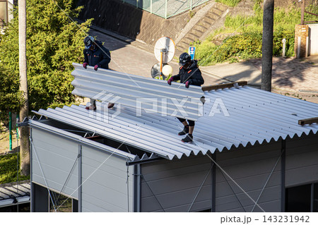 空調服を着た建設作業員・とび職が仮設事務所を組立てる建設現場 143231942
