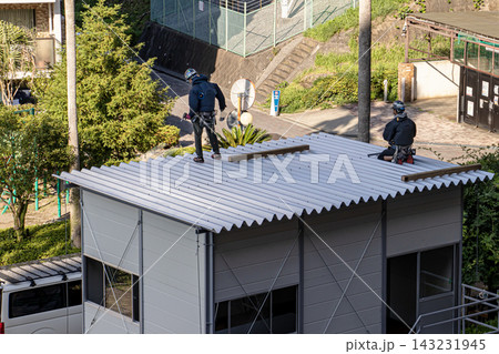 空調服を着た建設作業員・とび職が仮設事務所を組立てる建設現場 143231945