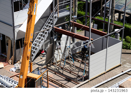 空調服を着た建設作業員・とび職が仮設事務所を組立てる建設現場 空調服を着た建設作業員・とび職が仮設事務所を組立てる建設現場 143231963