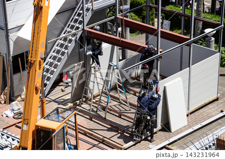 空調服を着た建設作業員・とび職が仮設事務所を組立てる建設現場 空調服を着た建設作業員・とび職が仮設事務所を組立てる建設現場 143231964