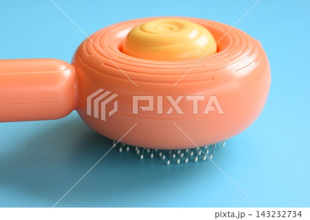 pastel orange comb on blue background, hair brush for pet 143232734