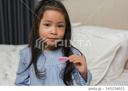 sick preschool child girl with liquid medicine in spoon sick preschool child girl with liquid medicine in spoon 143234011