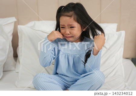 sad sick preschoool child girl crying in bed feeling unwell sad sick preschoool child girl crying in bed feeling unwell 143234012