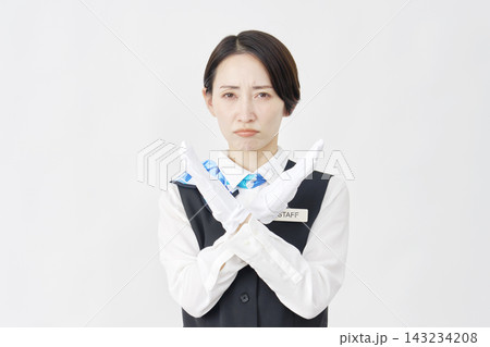女性スタッフ　受付・バスガイド　腕でばつ印のポーズ　白背景 143234208