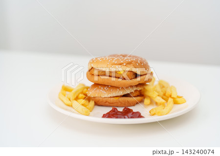juicy beef burger with melted cheddar cheese, potato chips on table. Unhealthy, High calorie, Fast food craving, Obesity, diet, weight loss, junk food and lifestyle 143240074