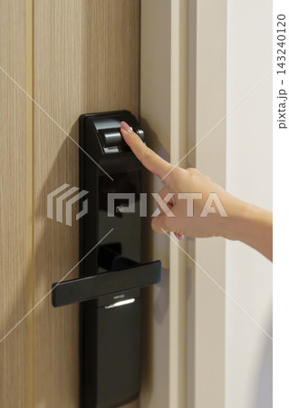 Hand using fingerprint scan for smart digital door lock while open or close the door at home or apartment. NFC Technology, keycard, PIN number, smartphone and contactless lifestyle concepts 143240120
