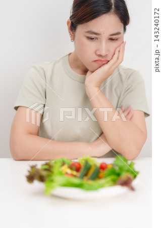 Unhappy woman disgust gesture and Bored to eat fresh organic vegetables. healthy nutrition, weight loss, clean eating, Healthy food eating, Vegan, Wellness, Green dieting and Healthy lifestyle 143240172