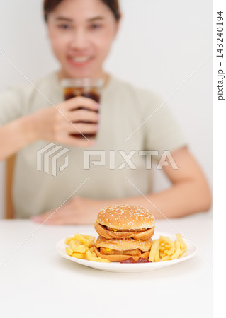 woman eating Juicy beef burger with melted cheddar cheese, potato chips and carbonated Soft drinks. Unhealthy, High calorie, Fast food craving, Obesity, diet, weight loss, junk food and lifestyle woman eating Juicy beef burger with melted cheddar cheese, potato chips and carbonated Soft drinks. Unhealthy, High calorie, Fast food craving, Obesity, diet, weight loss, junk food and lifestyle 143240194